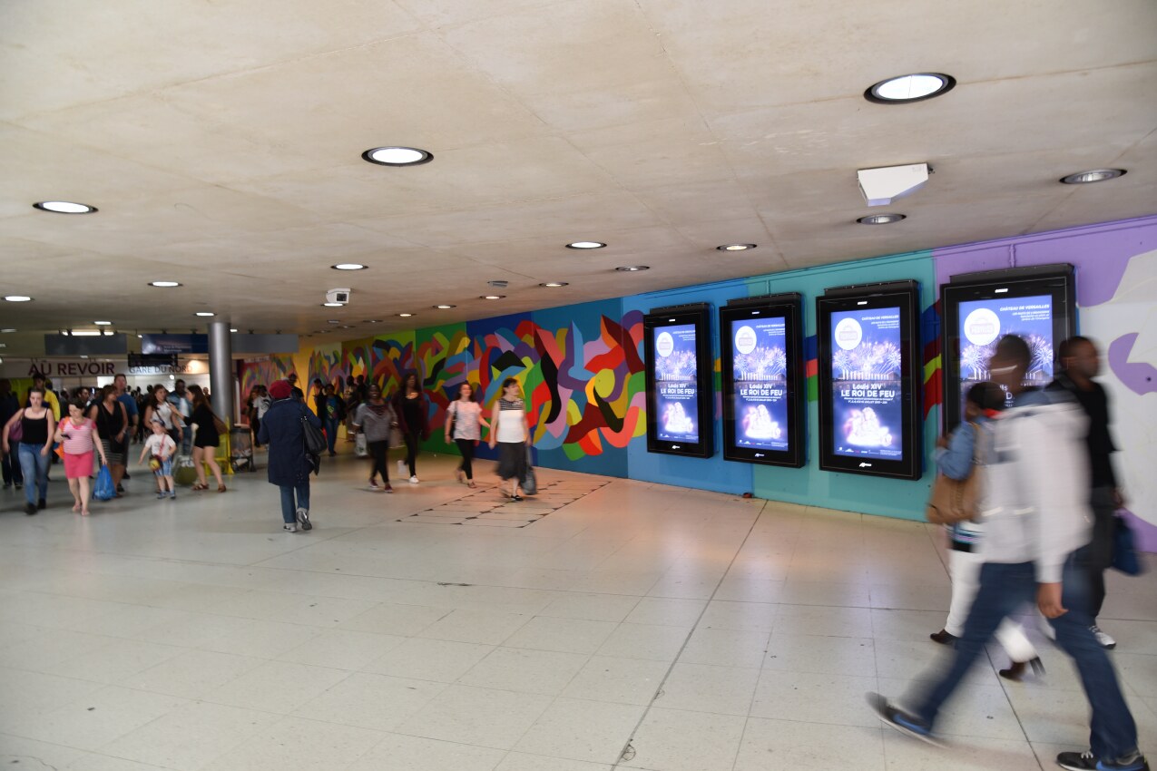 Long station view of Kool Koor’s chromatic mural at Gare du Nord